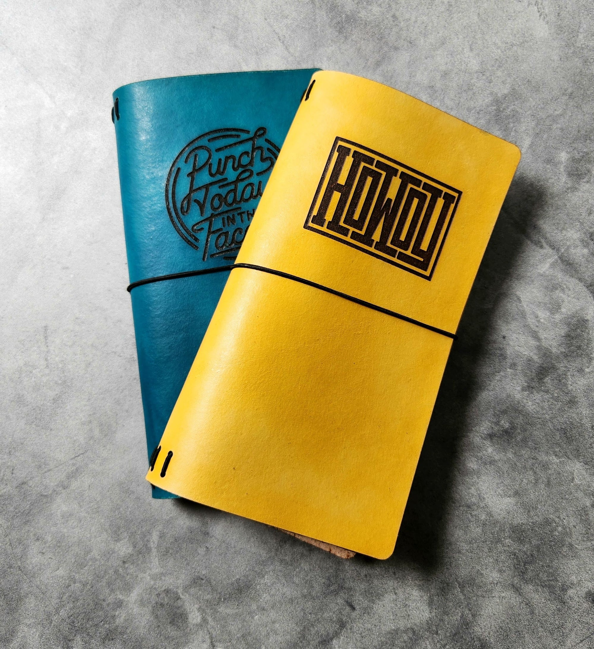 tall skinny leather engraved journals with various designs in blue and yellow